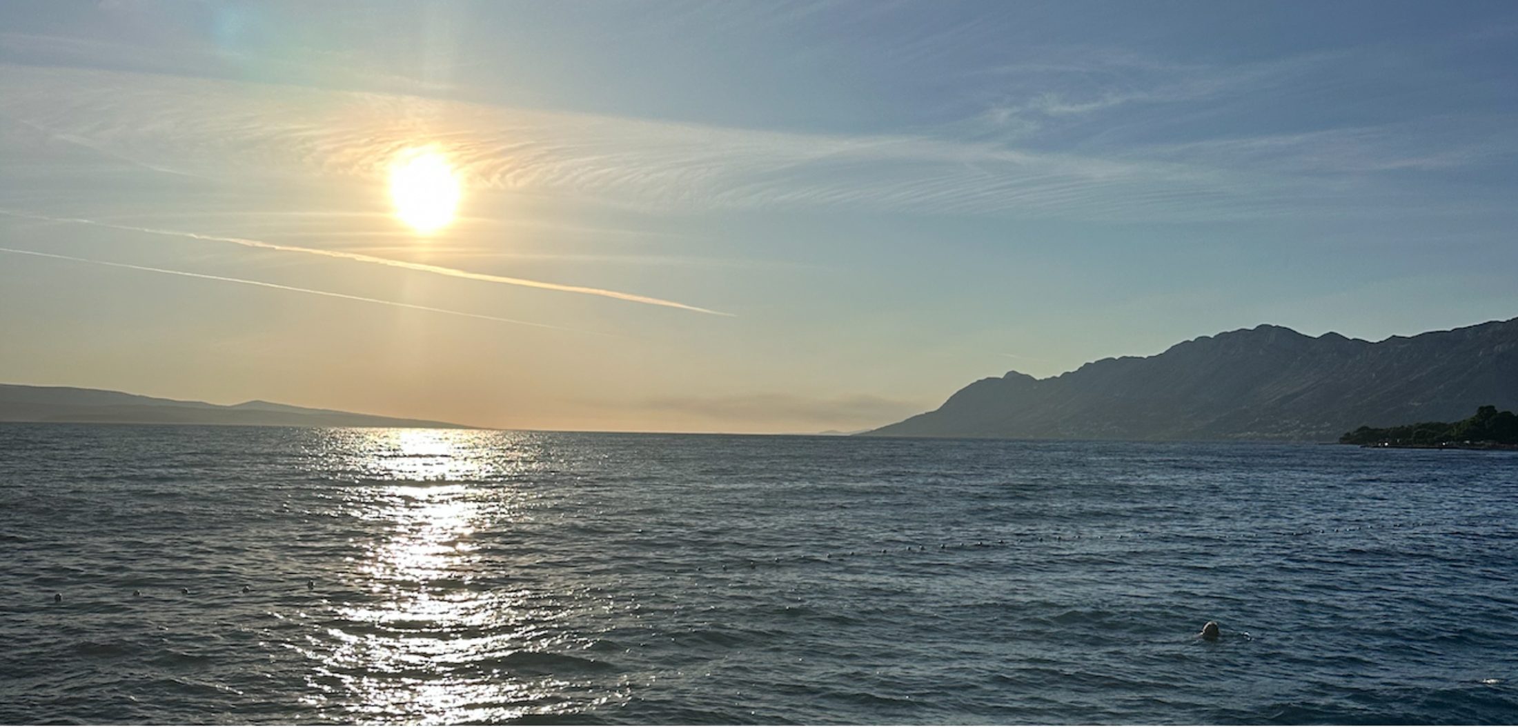 Sonnenuntergang über dem Meer, Bergkette am Horizont
