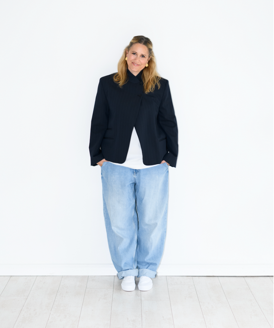 Miriam Zillmann in ganzer Figur vor einer weißen Wand